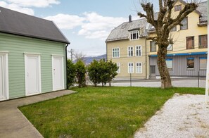 A residential area with houses, a grassy yard, and a tree. - Modern apartment in Laksevåg with parking (Bergen)