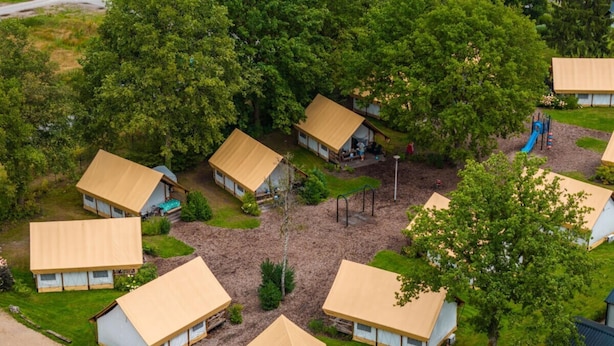 Ein Campingplatz mit mehreren Zelten und einem Spielplatz.