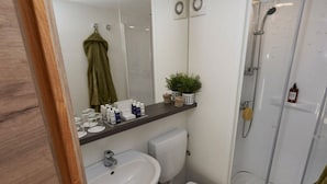 Ein Badezimmer mit Waschbecken, Toilette, Dusche und Spiegel.