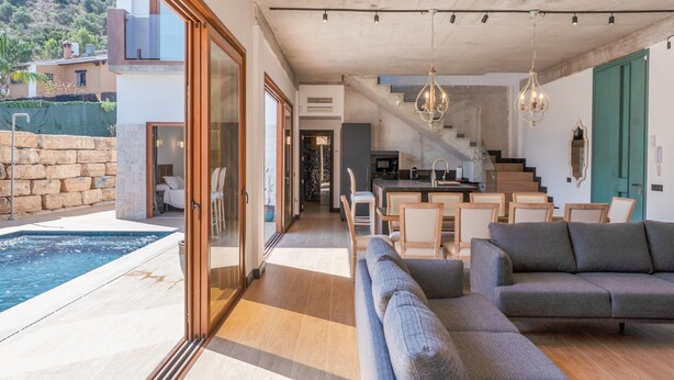A modern interior with a pool, a staircase, and a dining area.