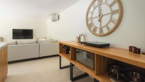 A modern kitchen with a wooden countertop, a large wall clock, and a built-in oven. - One bedroom apartment, large private yard in beautiful Playa Langosta with AC (Playa Langosta)