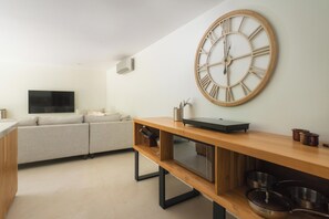 A modern kitchen with a wooden countertop, a large wall clock, and a built-in oven. - One bedroom apartment, large private yard in beautiful Playa Langosta with AC (Playa Langosta)