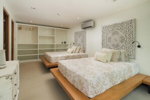 Un dormitorio con dos camas, un armario y decoración en la pared.
