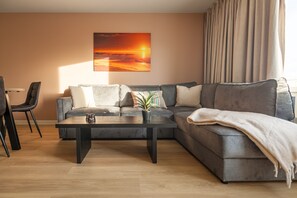 A living room with a sofa, a coffee table, and a painting on the wall.