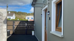 A residential property with a gated entrance, a small porch, and a window with a wooden frame. - Studio Sleeps 2 -private Hot Tub -enclosed Garden (Killarney)