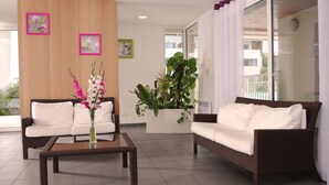 A modern living room with two sofas, a coffee table, and a large potted plant. - À 200 m de la plage et du golf | Piscines | Sauna (Moliets)