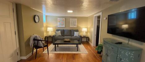 A living room with a sofa, coffee table, TV, and a cabinet.
