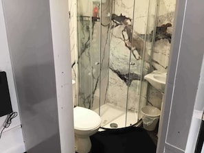 A bathroom with a toilet, bidet, and a glass shower enclosure. - Studio Sleeps 2 With Parking (Oldbury)