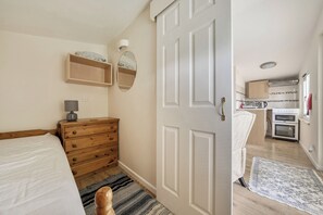 Ein Schlafzimmer mit einem hölzernen Schminktisch, einer Nachttischlampe und einem Bett.