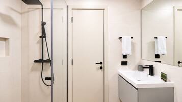 Un baño moderno con ducha, inodoro y lavabo.