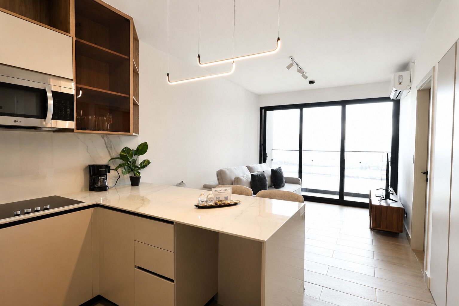 A modern kitchen with an island, a built-in microwave, and a coffee maker.