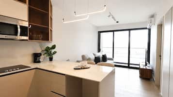 A modern kitchen with an island, a built-in microwave, and a coffee maker.