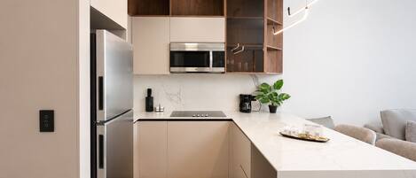 A modern kitchen with a built-in oven, microwave, and a coffee maker on the counter.