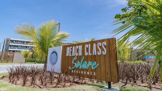 Placa para Beach Class Residence, com um edifício moderno ao fundo.
