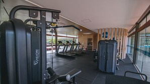 Uma academia com esteiras, um suporte para agachamento e máquinas de musculação.