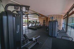 Ein Fitnessstudio mit Laufbändern, einer Kniebeugenhilfe und Krafttrainingsgeräten.