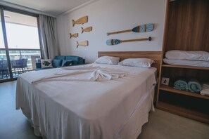 Hotellihuone, jossa on suuri sänky, vaatekaappi ja ikkunasta avautuva näkymä kaupunkiin.