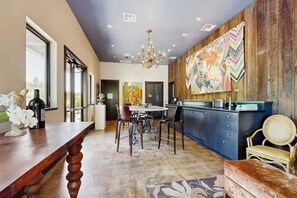 Une cuisine spacieuse dotée d’un grand îlot central, de touches de bois et d’un tableau coloré accroché au mur.