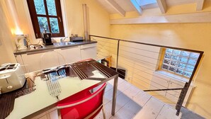 A kitchen with a window, a staircase, and a view of the outside. - Charming Suite in the Heart of Cannero Riviera, Lake Maggiore (Cannero Riviera)