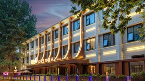 Ein modernes Hotel mit markanter Fassade, mehreren Stockwerken und guter Beleuchtung.