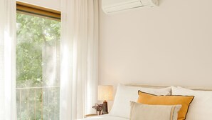 Une chambre d’hôtel avec un lit, une table de chevet, une lampe et une fenêtre avec des rideaux.