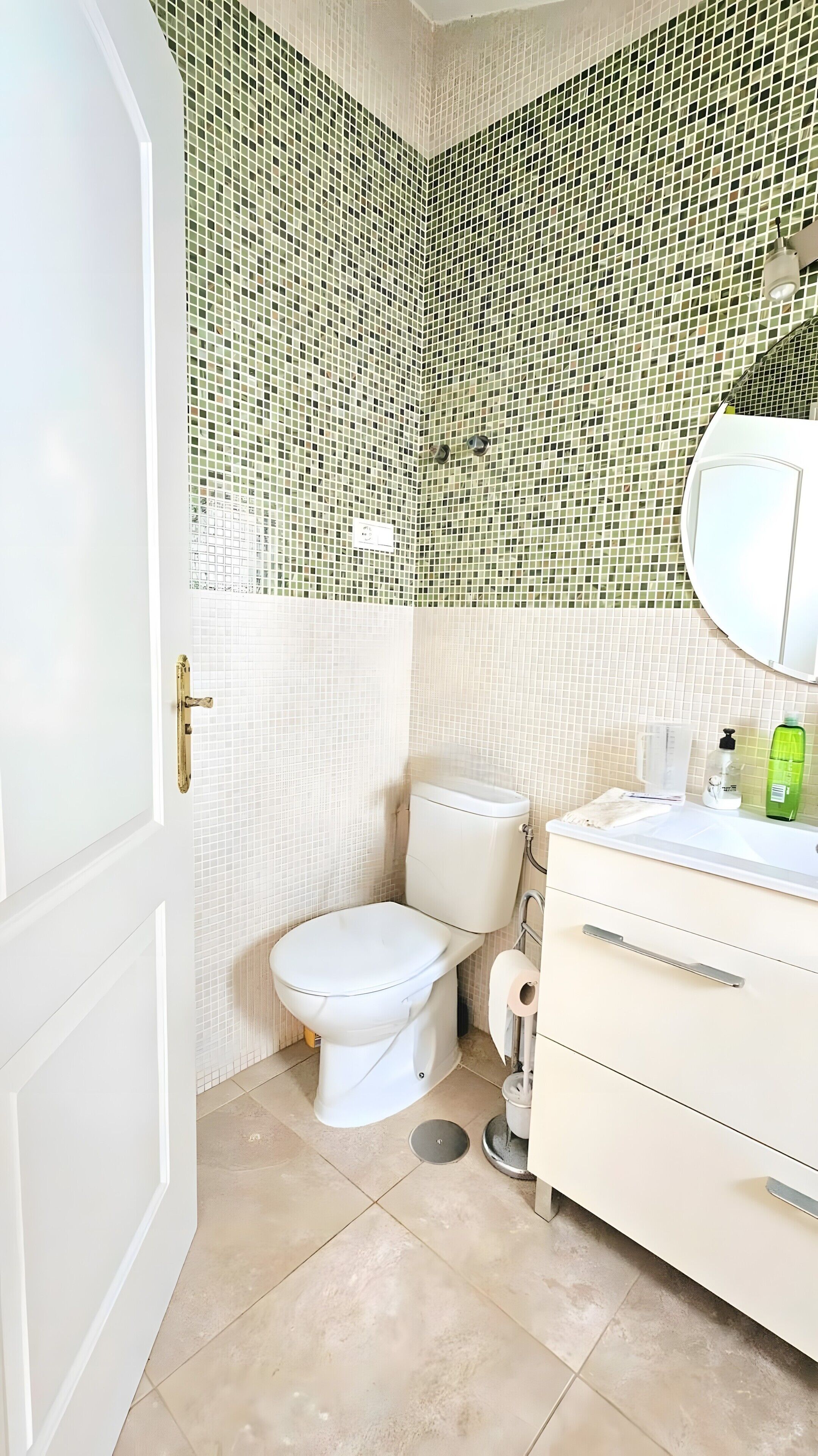 Ein Badezimmer mit Toilette, Waschbecken und Spiegel.