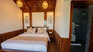 A wooden-framed bed with a white mattress, two wall-mounted lamps, and a shower area with a dark floor. - Premium King Bed Room Palette Hotel Amritsar (Amritsar)