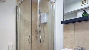 A modern bathroom with a glass-enclosed shower, a white sink, and a toilet. - Glastonbury Studio- Amazing Views and Free Parking (Glastonbury)