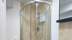 A bathroom with a glass-enclosed shower, a toilet, and a sink. - Glastonbury Studio- Amazing Views and Free Parking (Glastonbury)