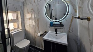 Ein Badezimmer mit Toilette, Waschbecken und Spiegel.