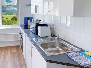 Eine moderne Küche mit einer Spüle aus Edelstahl, einem Toaster und einem blauen Schneidebrett.