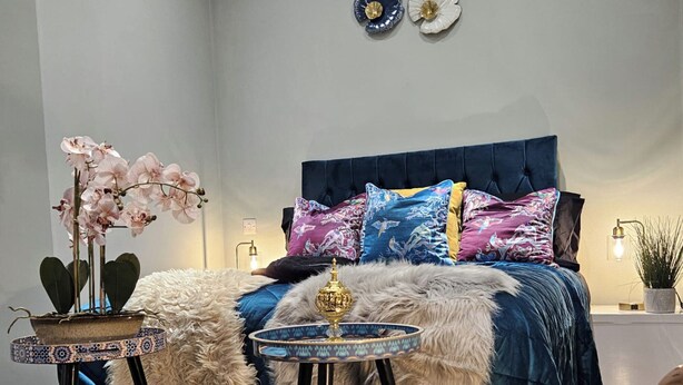 A bedroom with a blue upholstered headboard, a fluffy white rug, a decorative bowl, and a potted plant. - Airport Stays - Deluxe Studio London Heathrow (Hayes)
