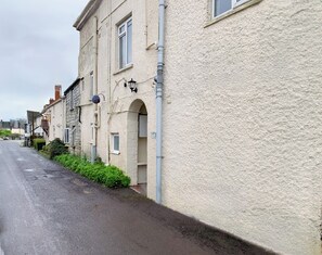 Eine enge Straße, gesäumt von traditionellen Gebäuden mit Steinwänden und Bogenfenstern.