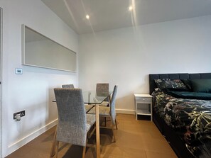 A bedroom with a bed, a bedside table, a chair, a desk, and a mirror. - Grosvenor Rd Studio - Sleeps 4, Pet Friendly, Wifi (St Albans)