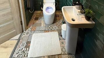 A bathroom with a toilet, sink, and mirror.