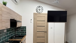 Una cocina moderna con armarios de madera, estufa negra y salpicadero con azulejos verdes.