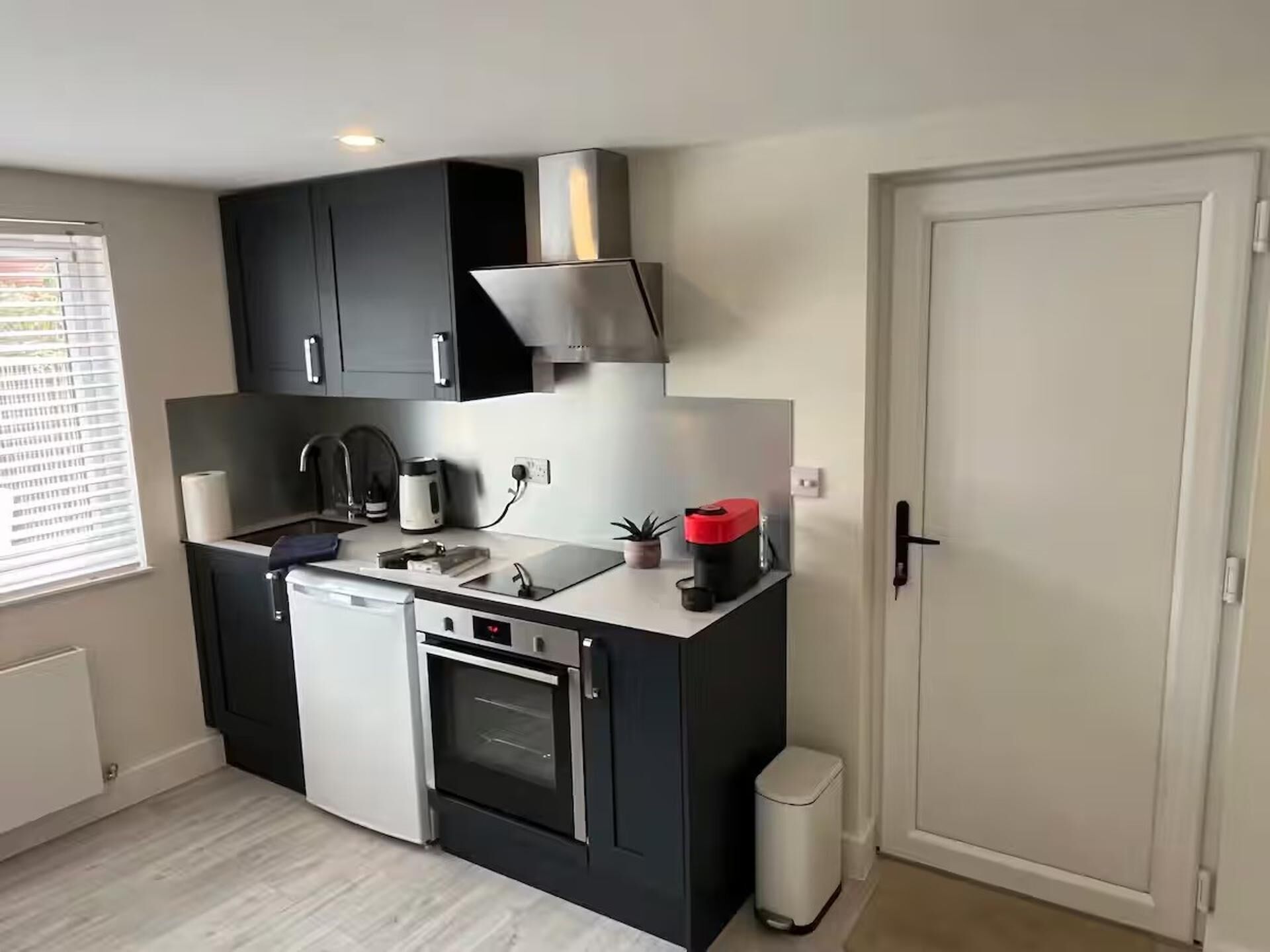 A compact kitchen with a dishwasher, oven, and a small sink.