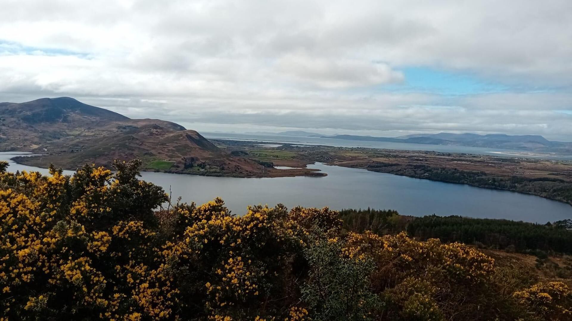A lake surrounded by hills and mountains.