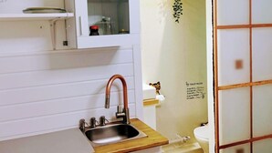 Une cuisine équipée d’un évier, d’un meuble et de toilettes.