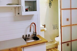 Eine Küche mit Spüle, Schrank und Toilette.