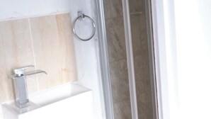A bathroom with a glass shower enclosure, a sink with a faucet, and a towel ring. - Cosy Studio Getaway - Free Parking & Central Links (South Ockendon)