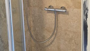 A glass-enclosed shower with a handheld showerhead and a wall-mounted faucet. - Cosy Studio Getaway - Free Parking & Central Links (South Ockendon)