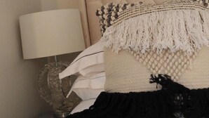 A bed with a tufted headboard, a white throw blanket, and a black blanket. - Cosy Studio Getaway - Free Parking & Central Links (South Ockendon)