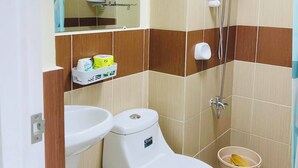 Un baño con inodoro, lavamanos y ducha.
