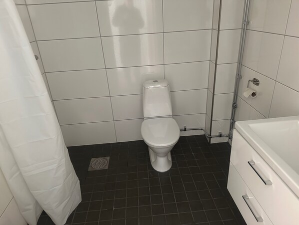 A bathroom with a toilet, a shower, and a bathtub.