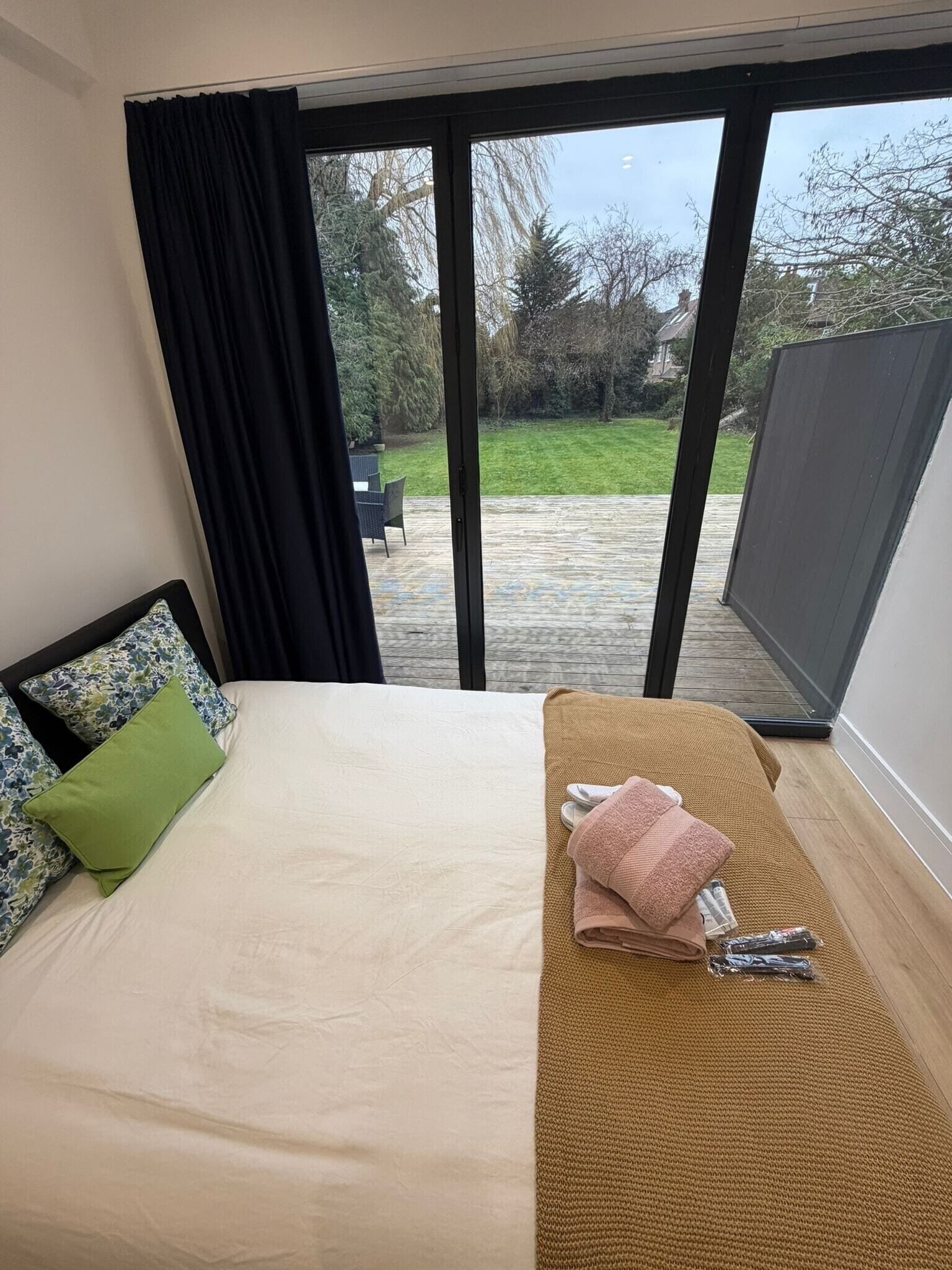 Un dormitorio con cama, vistas al exterior y una puerta corredera.