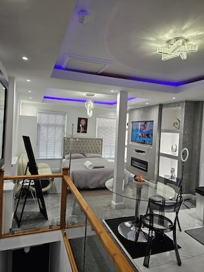 A modern hotel room with a bed, a TV, a desk, and a balcony. - Studio in Central Liverpool - Sleeps 2 - Parking (Liverpool)