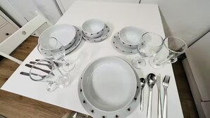 A white table set with plates, bowls, glasses, and cutlery. - Studio Sleeps 2 With Shared Hot Tub (London)