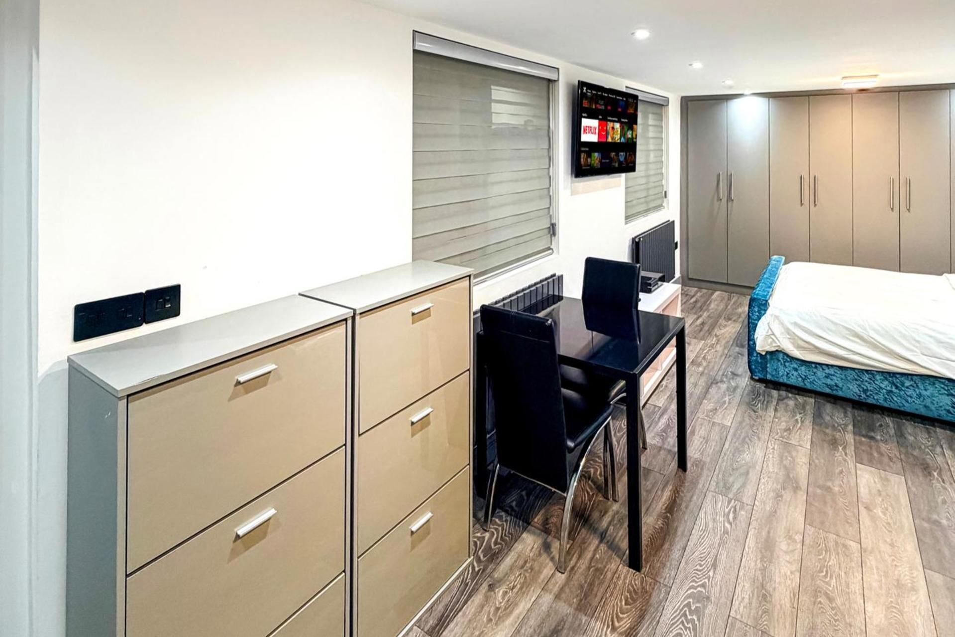 Ein Schlafzimmer mit Bett, Schreibtisch und Kleiderschrank.