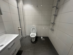 Ett modernt badrum med toalett, dusch och badkar.